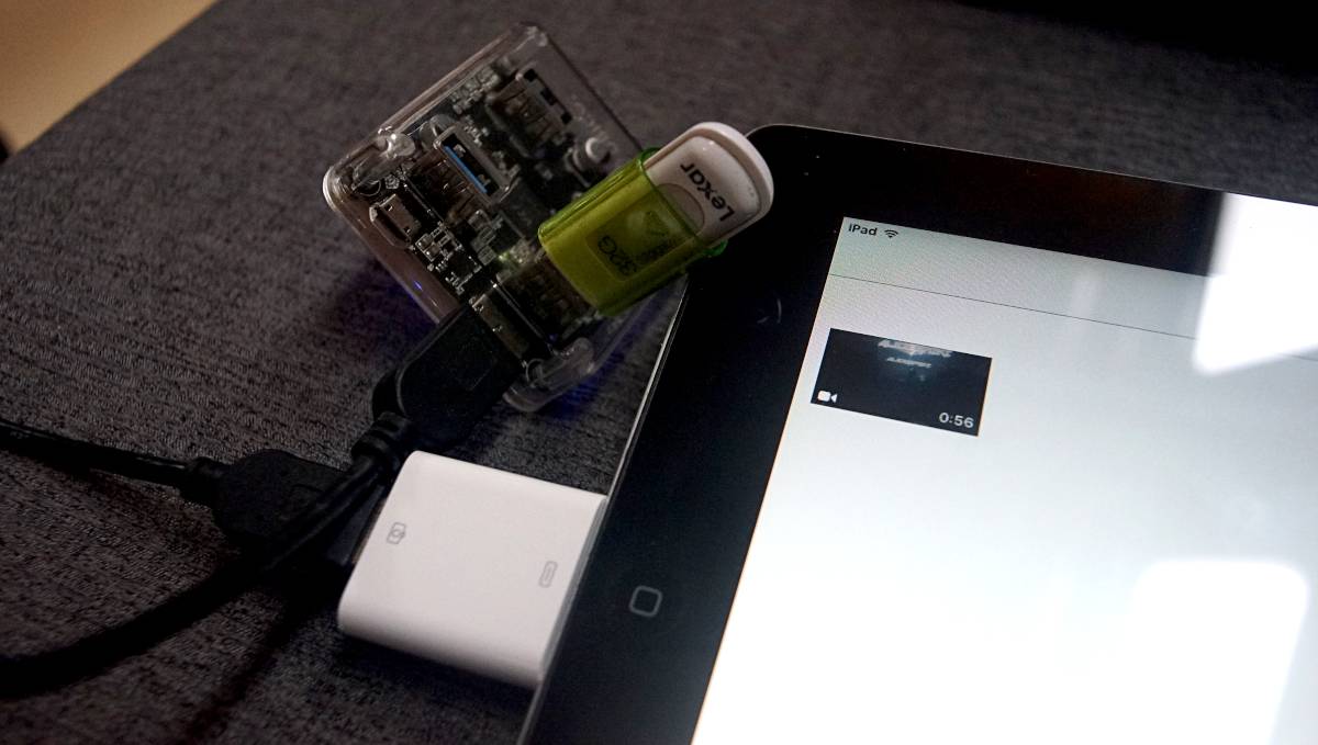 a 32gb usb stick plugged into a usb hub which is in turn connected to a 30-pin adapter and finally, into an ipad2. A video file is visible on screen