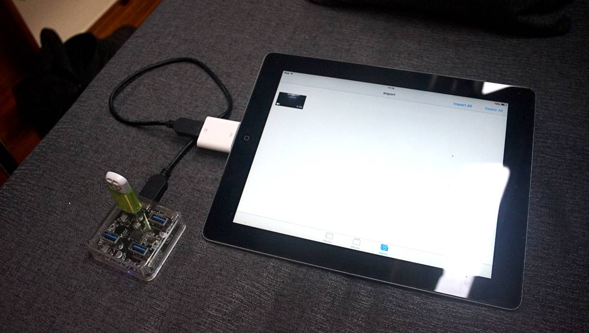 a 32gb usb stick plugged into a usb hub which is in turn connected to a 30-pin adapter and finally, into an ipad2. A video file is visible on screen