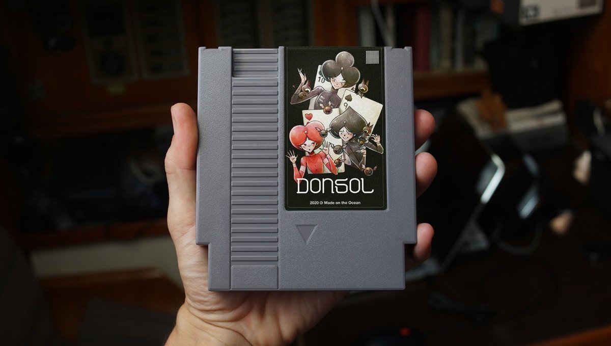A NES cart of Donsol A hand holding a NES cart of the game Donsol