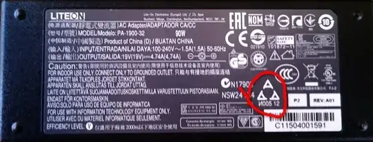 label of a laptop charger with the "three A's arranged into a triangle" symbol, circled with a red freehand circle with drop shadow