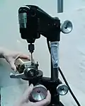 1. Drilling crosswise through the head of an obstinate capscrew in the barrel of the Biocut 2030 microtome. The drill diameter is approximately equal to the depth of the socket minus clearance from the end of the screw head. In this case a 2.2 mm hole is drilled in a M4 screw. Locate a center punch mark carefully. A preliminary small pilot hole helps to prevent the drill from drifting off center.