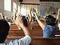 Both hands raised in worship may occur.