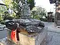 Statue of a red turtle carrying a bell on its back.