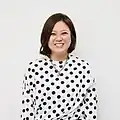 Smiling woman wearing white dress with black polka dots