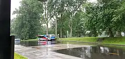 Gray, red and blue bus, seen from a distance