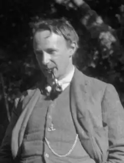 Black-and-white photo of man wearing a suit with a pipe in his mouth