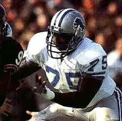 Lomas Brown in a Detroit Lions uniform with his hands up, ready to make contact.