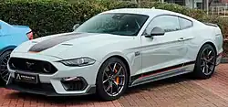Vibrant front-three quarters view photo of a light grey coupe