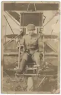Photograph of Ruth Law sitting in an airplane while wearing a military uniform.