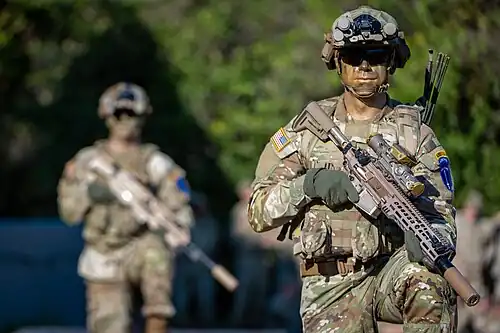 Soldiers from Training and Doctrine Command with an XM7 rifle (near) and XM250 light machine gun (far).