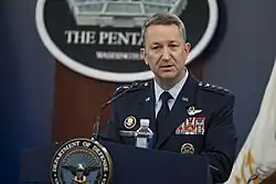 A man speaking behind a podium