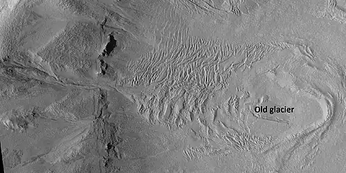 Glacier on a crater floor, as seen by HiRISE under HiWish program The cracks in the glacier may be crevasses. There is also a gully system on the crater wall. Location is Casius quadrangle.