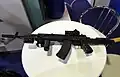 The ambidextrous ejection port and reversible charging handle above the vertical foregrip of the first prototype design of the AK-12