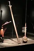 Center: six-string bowl zither (ligombo) of type B from the Nyamwezi in Central Tanzania. Missing gourd resonator.
