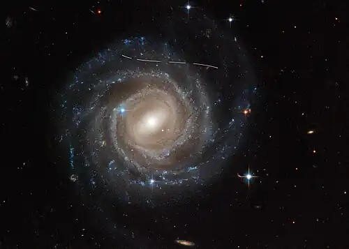 UGC 12158 imaged by the Hubble Space Telescope. The lines are a foreground asteroid moving through the field of view.