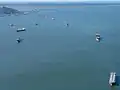 Multiple cargo ships with the bridge in the background