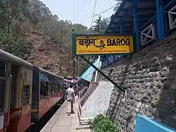 Narrow platform and train, with a bilingual sign