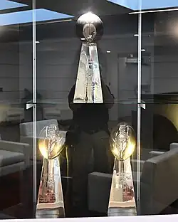 Three Super Bowl trophies displayed on a shelf.