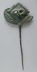Disk pin; face with one remaining inlaid eye