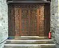 The doors beneath the tower are made from salvaged Tudor bench ends