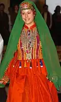 GI walks down the runway during a fashion show dressed in a colorful, traditional Afghan dress. The March 3, 2008