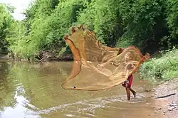 Boy casting from a riverbank