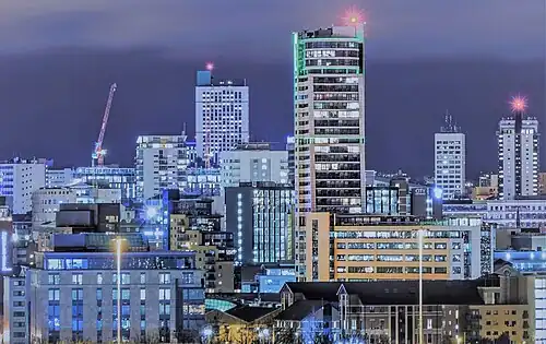 A cluster of modernist office buildings in at night.