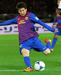 A man, wearing a blue and red football shirt.