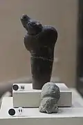 Sculpture casts from El-Wad, Natufian: polished bone sickle handle in the shape of a young deer (?); carved and engraved human head in calcite. Museum of National Archaeology.