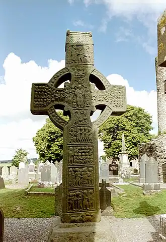Muiredach's High Cross (9th century) clearly depicting the Irish léine and mantles. Shoes or brogues and pants were also commonplace in Ireland since the early medieval period long before the Anglo-Normans came to Ireland.