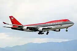 Side view of four-engine jet climbing in the sky.