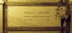 A marble gravestone on the wall of a crypt
