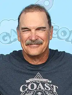 Warburton squinting at a camera