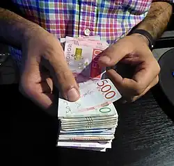 Image 12A person counts a bundle of different Swedish banknotes. (from Money)