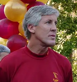 A color photograph of a man wearing a red shirt