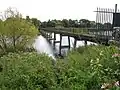 a view across a pedestrian bridge from a nearby bank