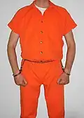 Inmate in belly chain with the arms cuffed parallel at the side