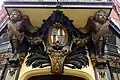 Coat of arms between angels above corner doorway