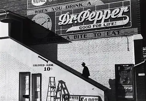 Image 8 Racial segregation in the United States Photo: Marion Post Wolcott; Restoration: Lise Broer An African American man climbs the stairs to a theater's "colored" entrance in Belzoni, Mississippi, in 1939. The door on the ground floor is labeled "white men only". De jure (legally enforced) racial segregation in the United States was eliminated by a series of Supreme Court decisions starting with Brown v. Board of Education in 1954. More selected pictures