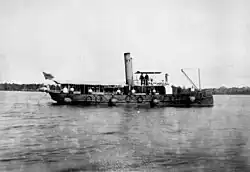Submarine minefield service vessel "Miner" with cylindrical mines and connecting cables hanging over side.[gallery 7]