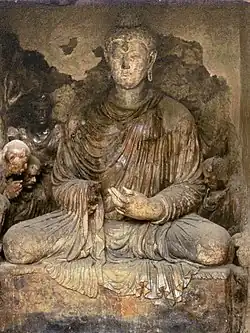 Seated Buddha with Vajrapani-Alexander attendant. Tapa Shotor (Niche V3).[24]