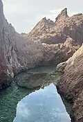 Tide pool surrounded by volcanic rock formations