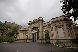 Arched gate with a small lodge to right and left
